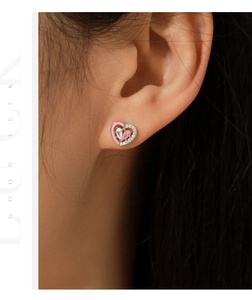 Macro view of a S925 silver heart stud earring with pink enamel and sparkling zircons