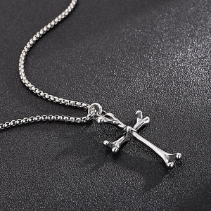 Detailed view of silver stainless steel cross bone pendant on a delicate box chain