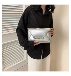 Dettaglio pochette a busta argento con trama intrecciata e bordo in metallo dorato