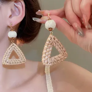 Bohemian woven triangle earrings with white cotton ball and wood bead details