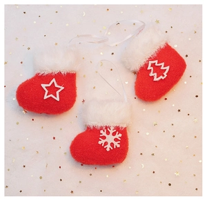 Three red plush Christmas stockings with white snowflakes and star embroidery on fur background
