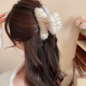 Détail d'une pince à cheveux en fausse fourrure pelucheuse à rayures sur cheveux longs