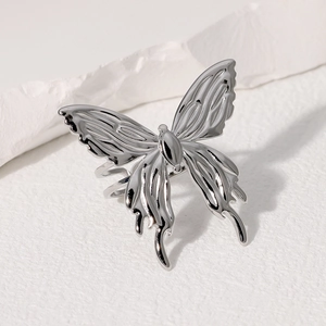 Bague ouverte papillon élégante en acier inoxydable argenté sur fond texturé blanc