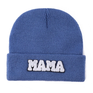 Detailed close-up of MAMA towel embroidery on blue knit beanie with clear fabric texture