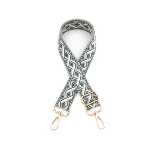 Détail de la bandoulière tissée gris-blanc avec mousquetons en métal doré poli brillant