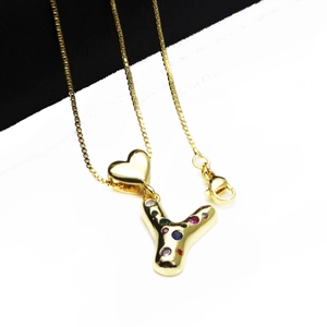 Close-up of gold plated heart and letter Y pendant with colorful zircons on box chain