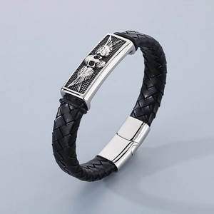 Close-up of braided black leather bracelet with winged skull metal plate and magnetic clasp