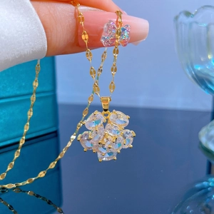 Detail of gold flower necklace with iridescent stones and a crystal butterfly charm