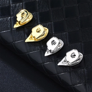 Close-up of gold and silver plated heart-shaped tooth grillz on black leather