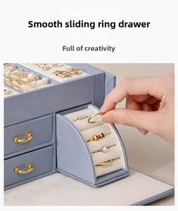 Detail of light blue leather jewelry box featuring smooth sliding arc ring storage drawer
