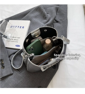 Spacious interior of silver bucket bag with multiple compartments and chain detail