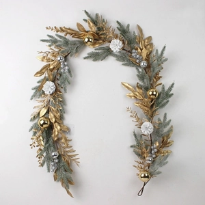 Christmas wreath detail with gold leaves, pine cones and shiny ornaments on frosted pine