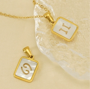 Vue détaillée du pendentif rectangulaire plaqué or 18K avec les symboles Gémeaux et Cancer