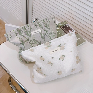 Close-up of floral fabric makeup bags with 'simple wish' label in home setting