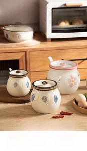 Close-up of heat-resistant ceramic seasoning jars with lids and spoons in a cozy kitchen