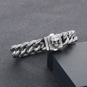 Close-up of vintage silver skull engraved clasp on punk style heavy Cuban link bracelet