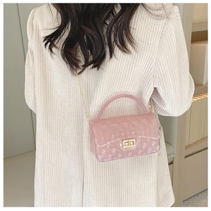 Detailed view of pink transparent jelly bag with quilted texture and pearl handle