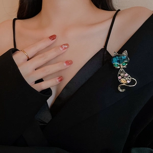 Close-up of cute rhinestone cat brooch with colorful crystals pinned on a black sweater