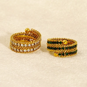 Macro shot of gold-plated multi-layer rings with twisted chain design and gemstones
