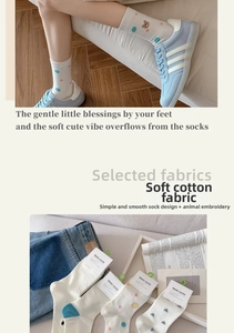 Detail of white cotton crew socks with cute bear and heart embroidery paired with sneakers