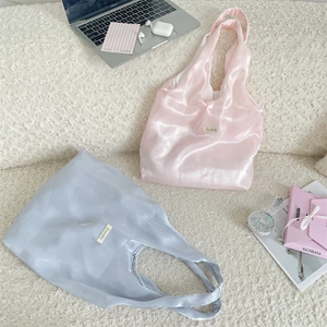 Detail view of satin tote bags in pink and blue grey with a silky pearlescent texture