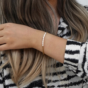 Detail of OT buckle pearl bracelet with gold metal chain on a female model wrist