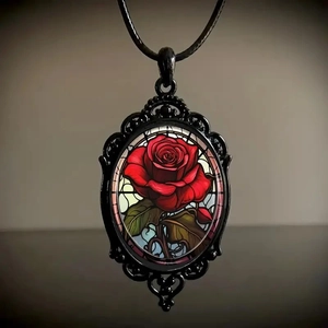 Macro shot of Gothic necklace featuring a red rose pendant inside a black filigree frame