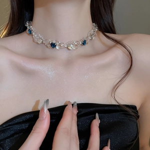 Detail of beaded choker necklace with sparkling blue heart crystal pendant on a model