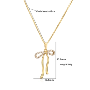 Detail of gold bow necklace with micro-set cubic zirconia and polished ribbon tassels