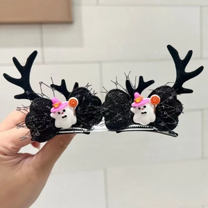 Close-up of Halloween deer horn hair clips with black sequin bows and ghost figurines