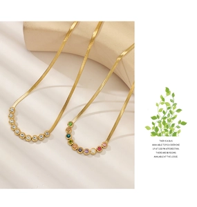 Detailed macro view of 18K gold-plated snake chains with white and colorful zircon pendants