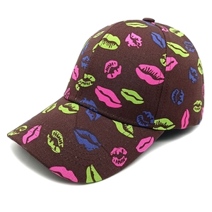 Detailed close-up of dark brown canvas baseball cap with vibrant colorful lip prints