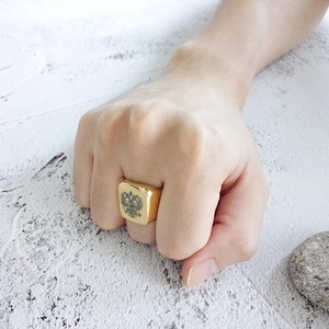 Close-up of golden men's signet ring with double-headed eagle relief on stone background