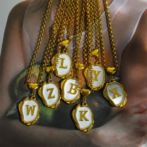 18K gold plated titanium necklace with white enamel initial pendants and heart charms