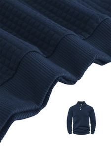 Detailed macro view of dark blue waffle knit fabric and ribbed cuffs on men's polo sweatshirt