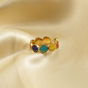 Colorful enamel smiley face gold plated stainless steel ring on silk background