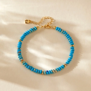 Detailaufnahme der blauen Kristallperlen und vergoldeten Elemente des Armbands