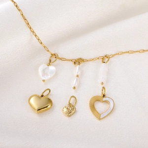 Detailed macro view of gold necklace with mother of pearl heart and pearl pendants