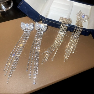 Close-up of sparkling rhinestone butterfly tassel earrings in gold and silver finishes