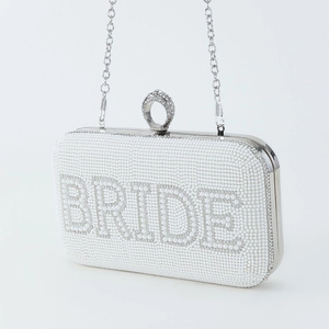 Macro view of white evening clutch with 'BRIDE' lettering in pearls and rhinestones