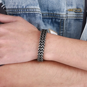 Close-up of a vintage punk lion head bracelet featuring a wheat pattern chain on a wrist