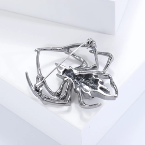 Detailed view of the metal spider brooch back showing the pin and safety clasp structure