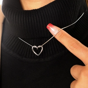 Minimalist silver hollow heart pendant necklace with sleek snake chain on black sweater