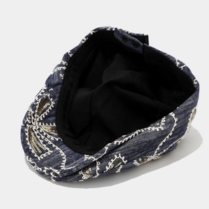 Denim newsboy cap with white floral embroidery and gold sequins for a stylish vintage look