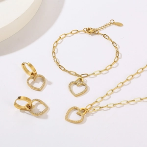 Detailed view of gold jewelry set with micro-pave heart pendants and dainty chain links
