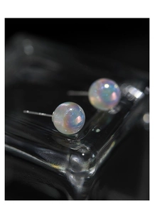Macro shot of S925 silver stud earrings with iridescent dreamlike mermaid pearls