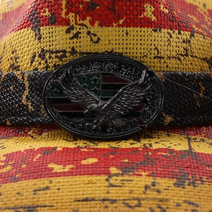 Macro detail of western straw hat with eagle buckle and red yellow stripe texture