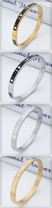 Detail of sun moon star engraved stainless steel bangles with secure side clasps