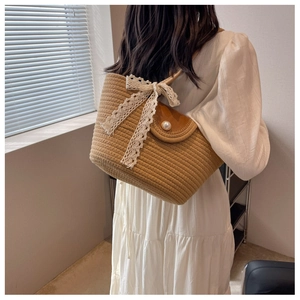 Detail of straw woven tote with white lace bow and pearl clasp for beach vacation fashion