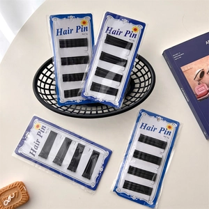 Set of four packs containing black metal bobby pins with ball tips on patterned cards